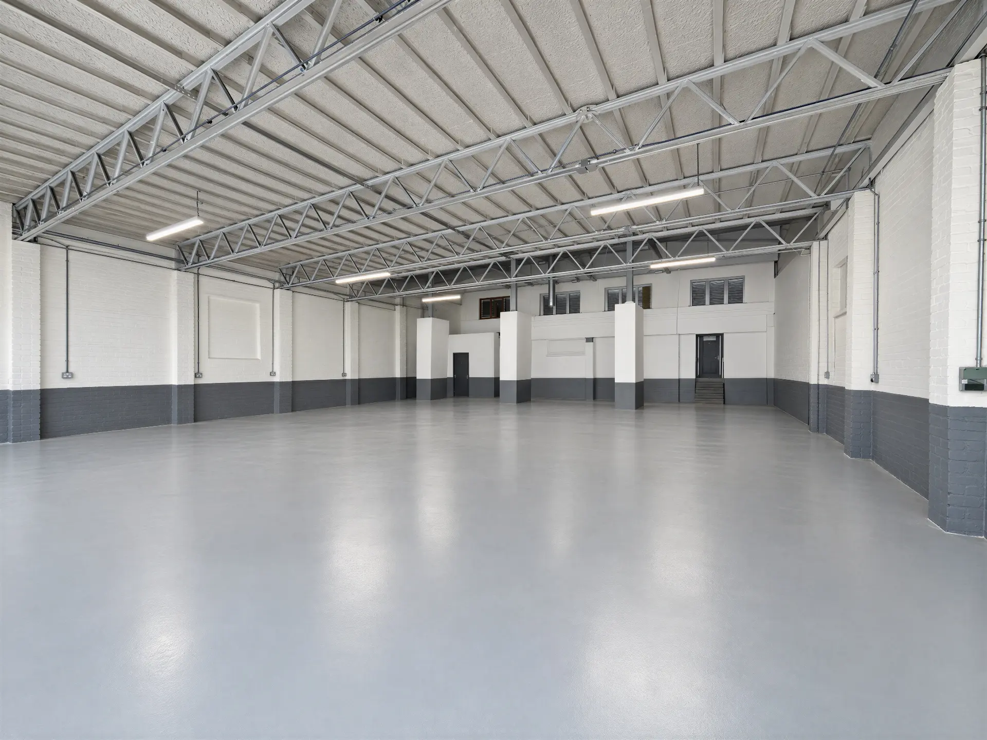 Refurbished warehouse interior with painted floors, LED lighting and a two-level office block